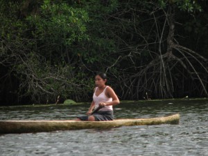 Village woman paddling canoe