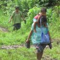 Mayan Q'eqchi woman carrying son down path