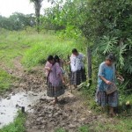 Almost there - Mayan Q'eqchi' women crossing one last mud puddle